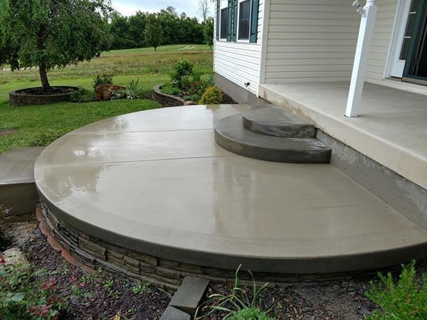 A circular concrete patio with steps leading to a house.