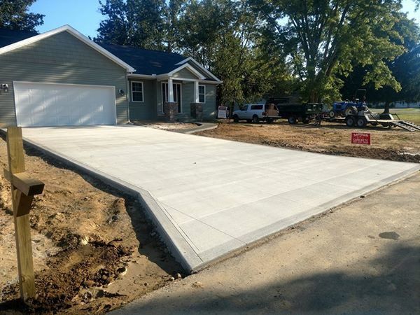A concrete driveway is being built in front of a house.