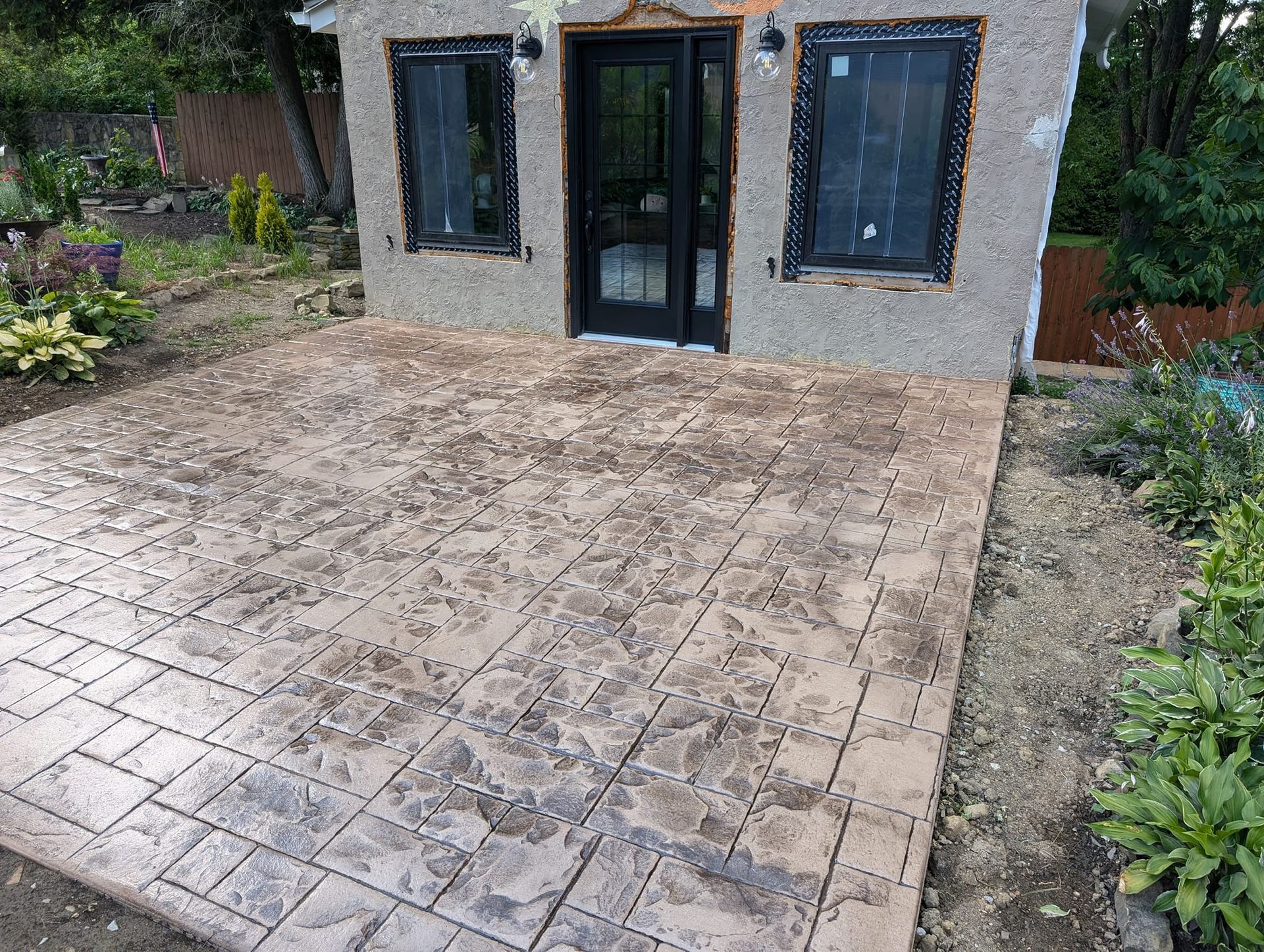 A small house with a concrete patio in front of it.