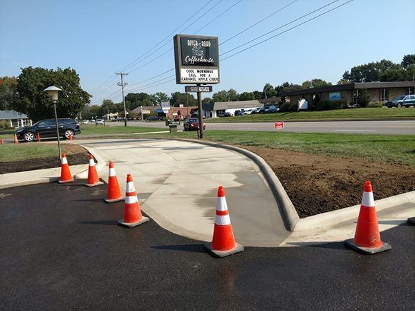 A row of orange and white traffic cones on the side of a road.