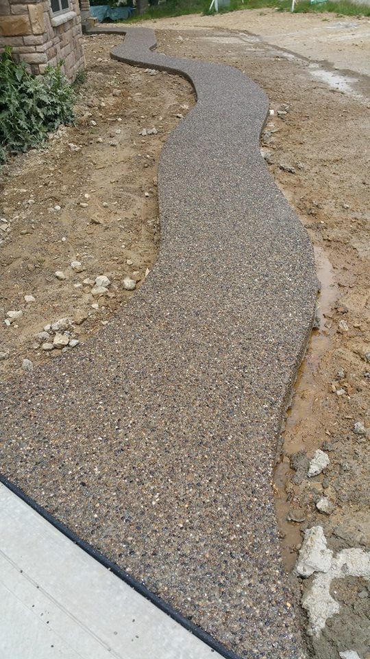 A concrete walkway is being built in front of a house.