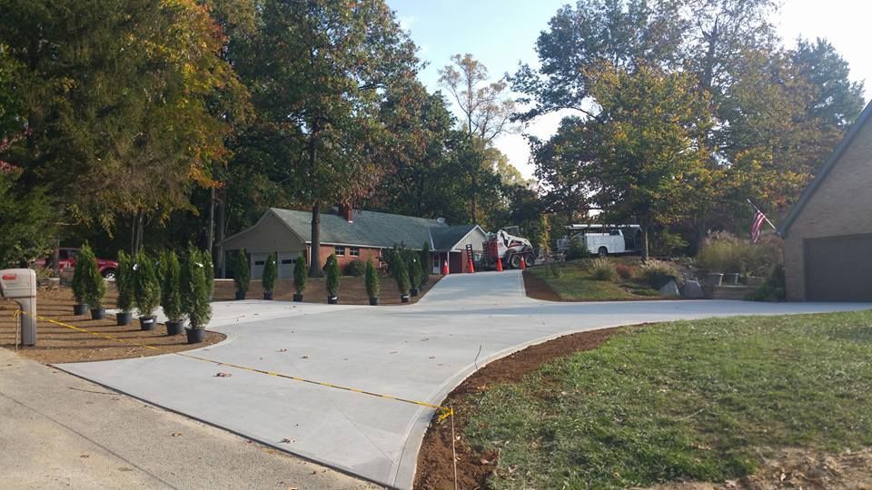 A driveway leading to a house with a mailbox in the middle of it.