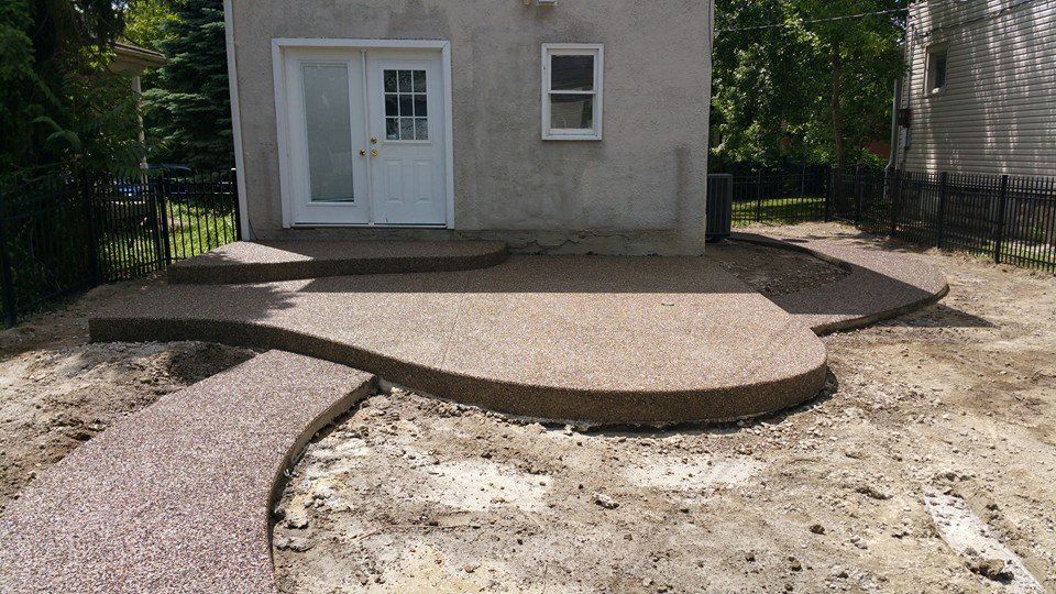 A concrete patio is being built in front of a house.