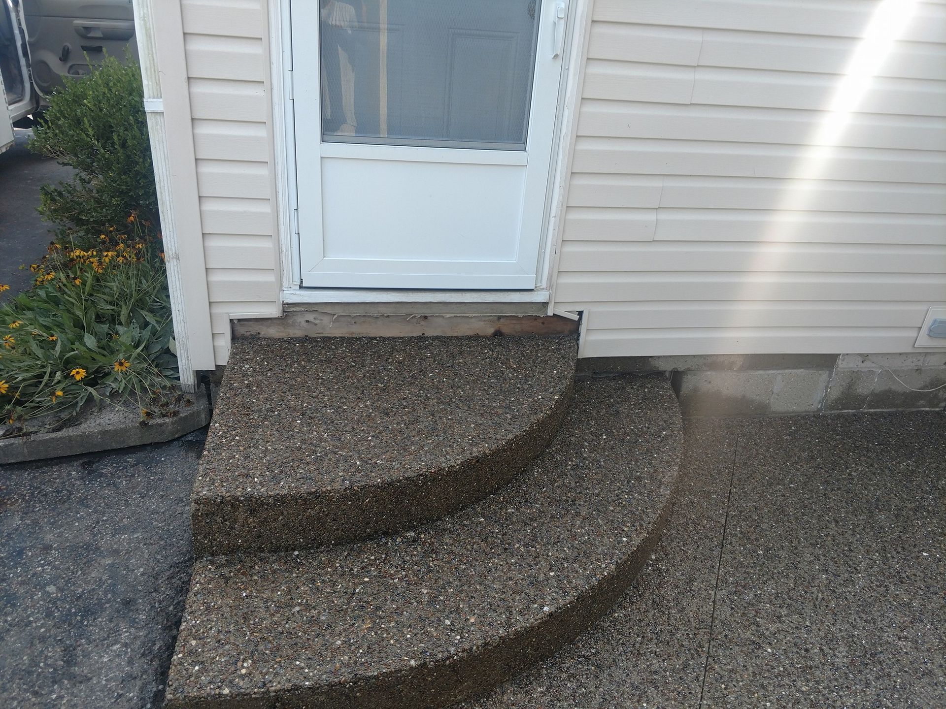 A set of concrete steps leading up to a door of a house.