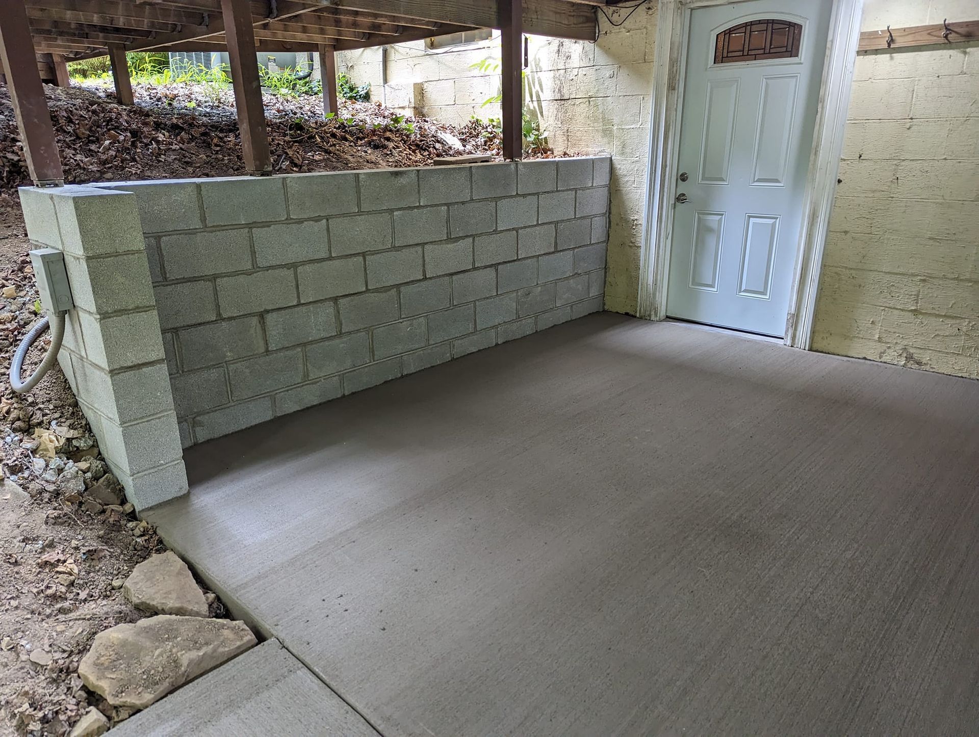 A room with a brick wall and a white door.
