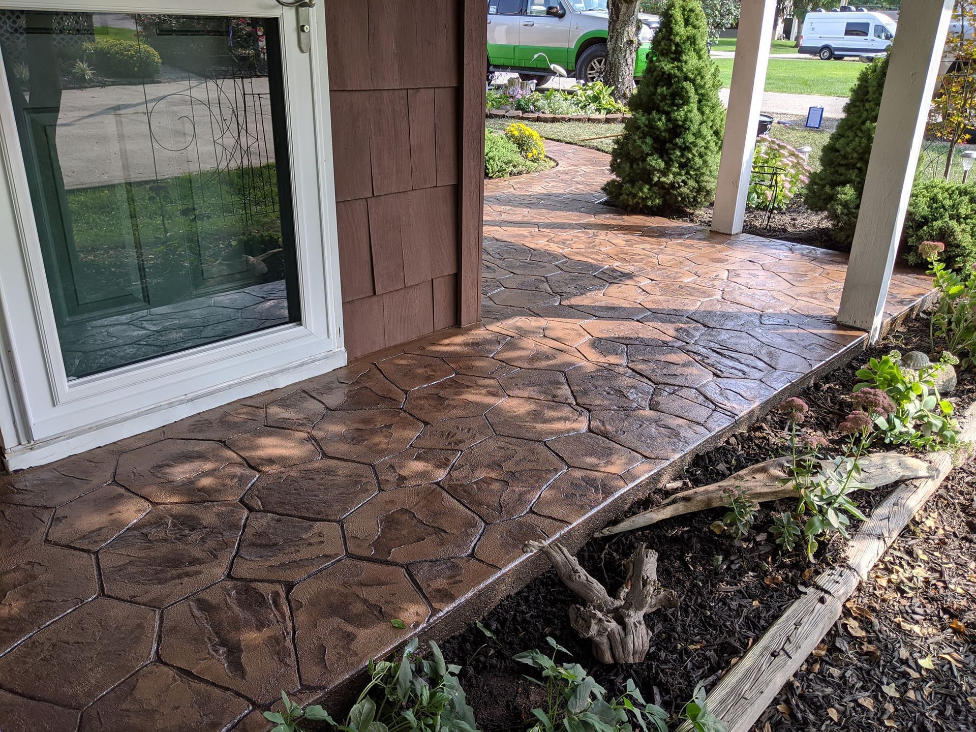 A concrete walkway leading to the front door of a house.