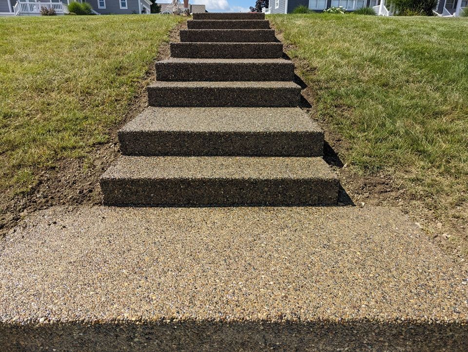 A set of concrete stairs leading up to a house.