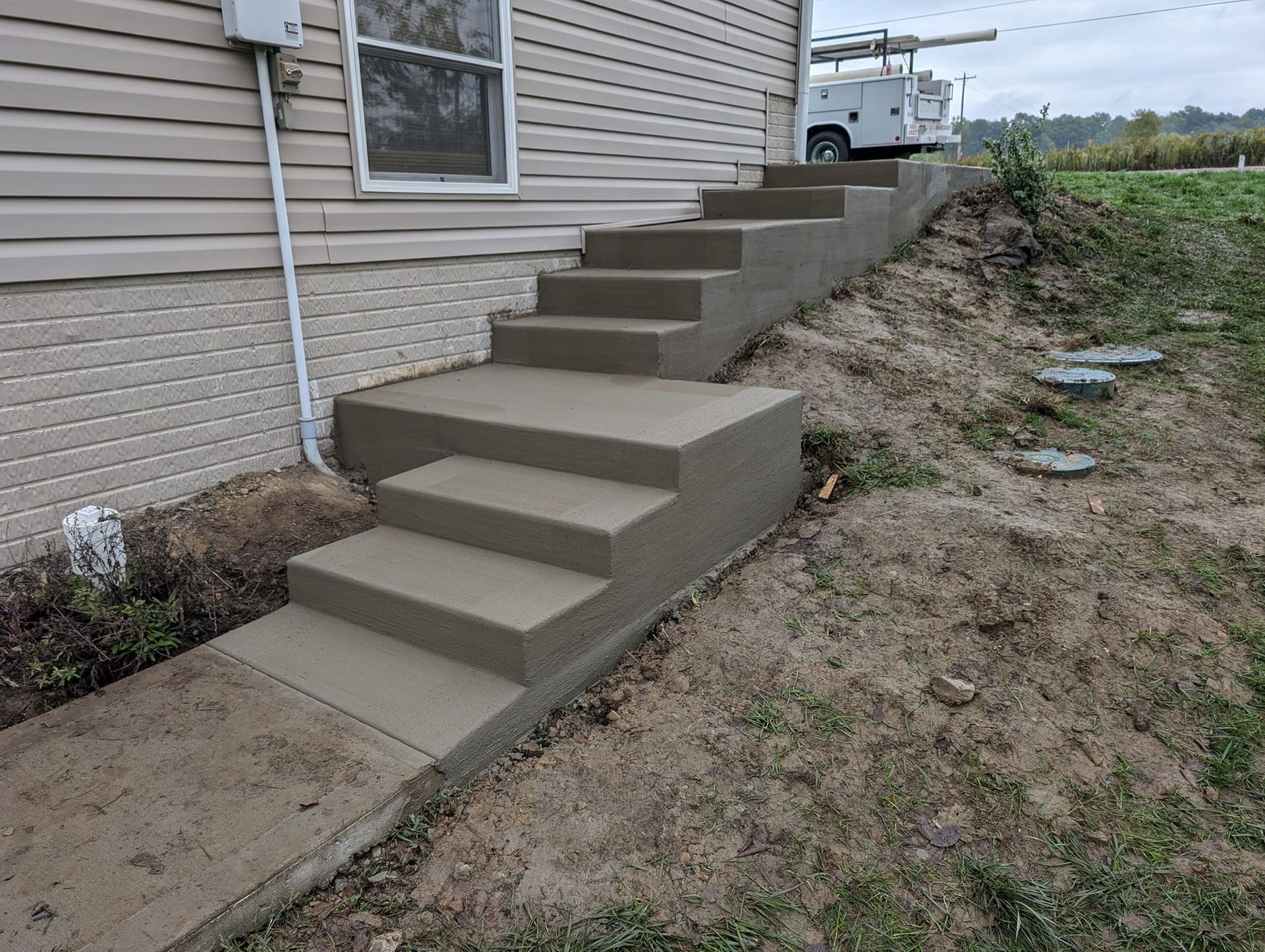 A set of concrete stairs leading up to a house.