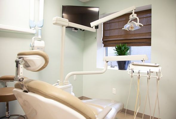 Dental office with dental chair, lights, and equipment.