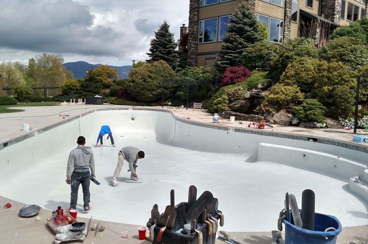 A group of men are working in a swimming pool.