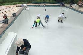 A group of people are painting a swimming pool.