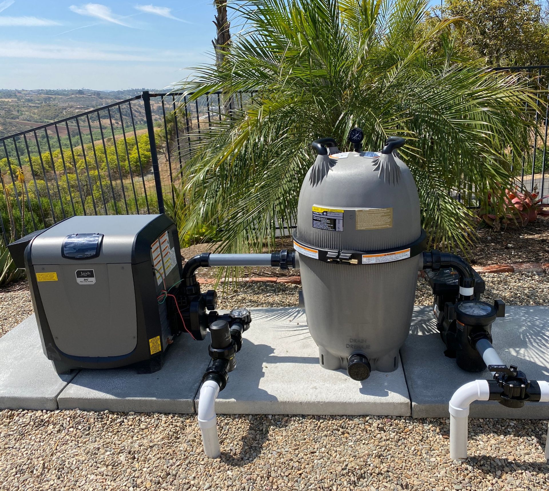 A swimming pool heater and filter are sitting on a concrete platform.