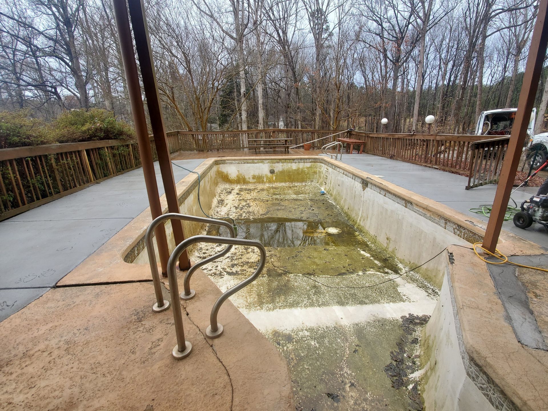 An empty swimming pool with stairs leading to it.