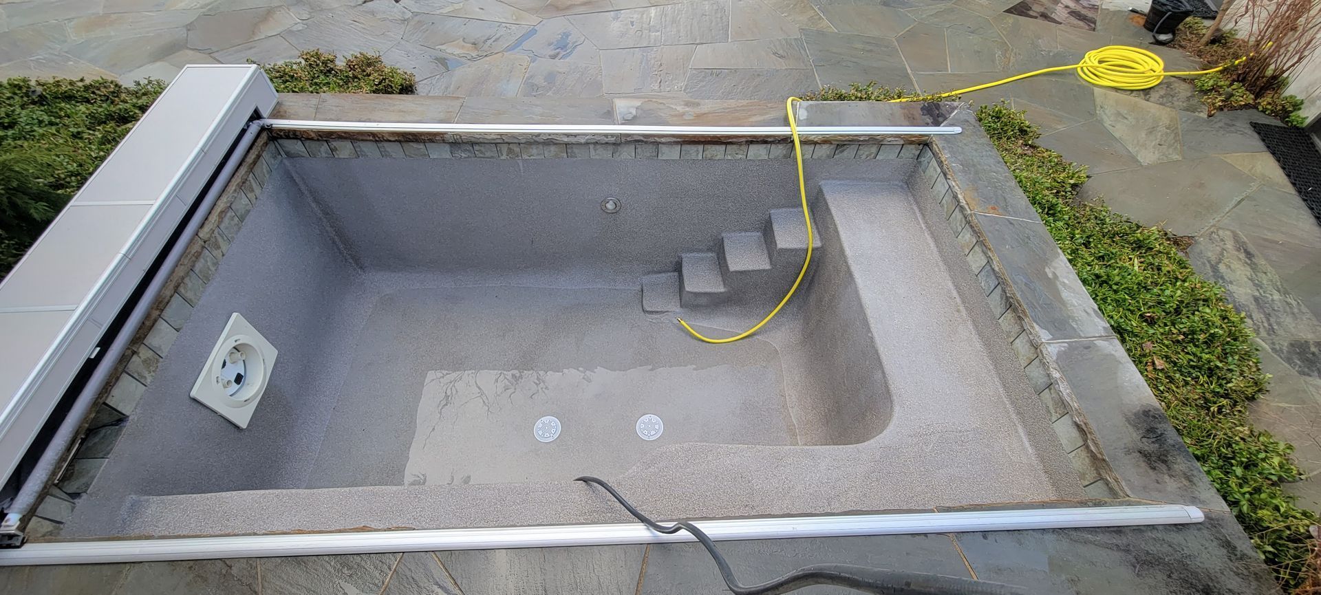 A swimming pool is being built in a backyard.