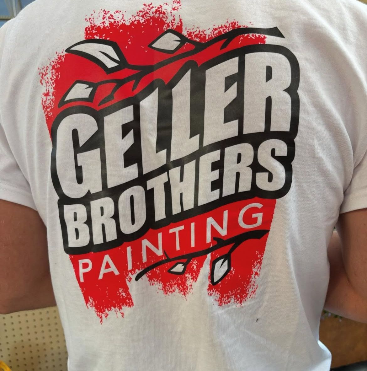 A person is wearing a shirt that says geller brothers painting.