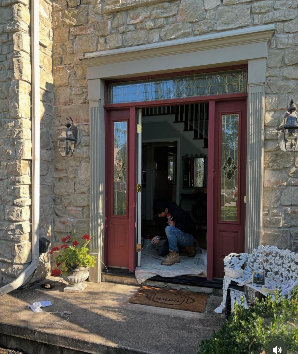 A man is sitting in the doorway of a house.