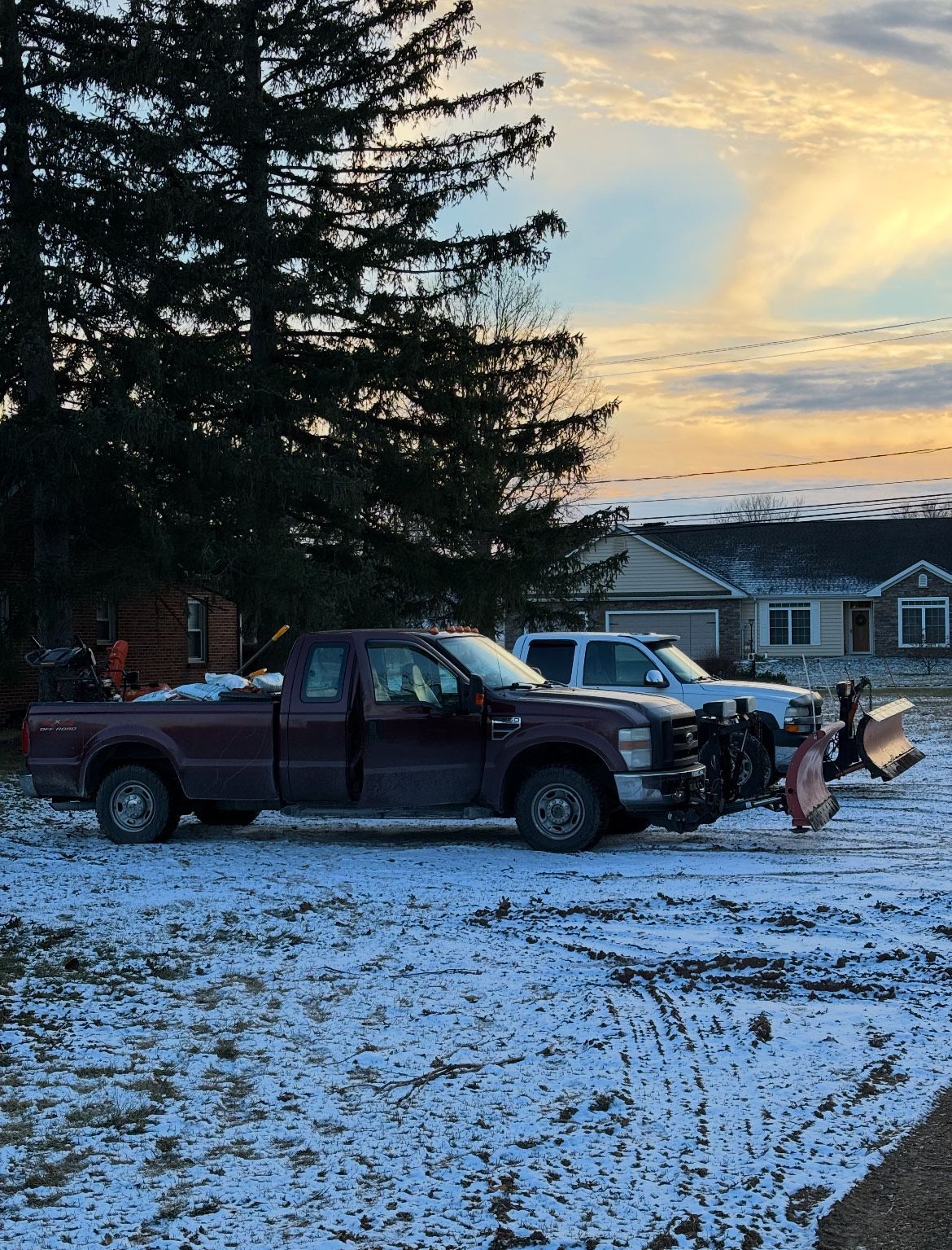 A purple truck is parked in a snowy parking lot.