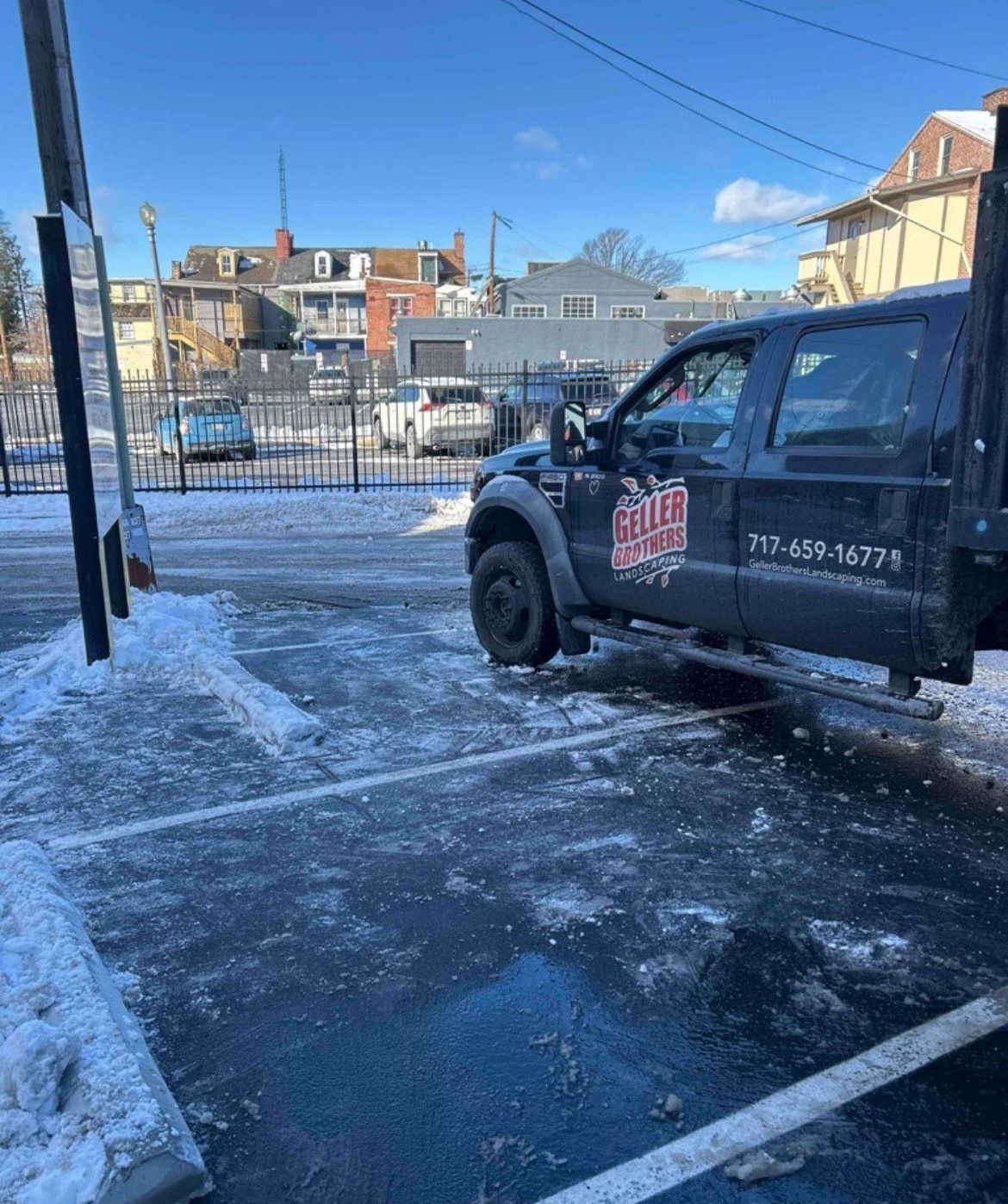 A black truck is parked in a snowy parking lot.