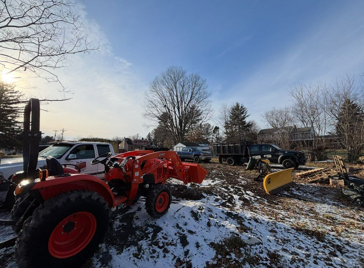 A red tractor is parked in a snowy field.