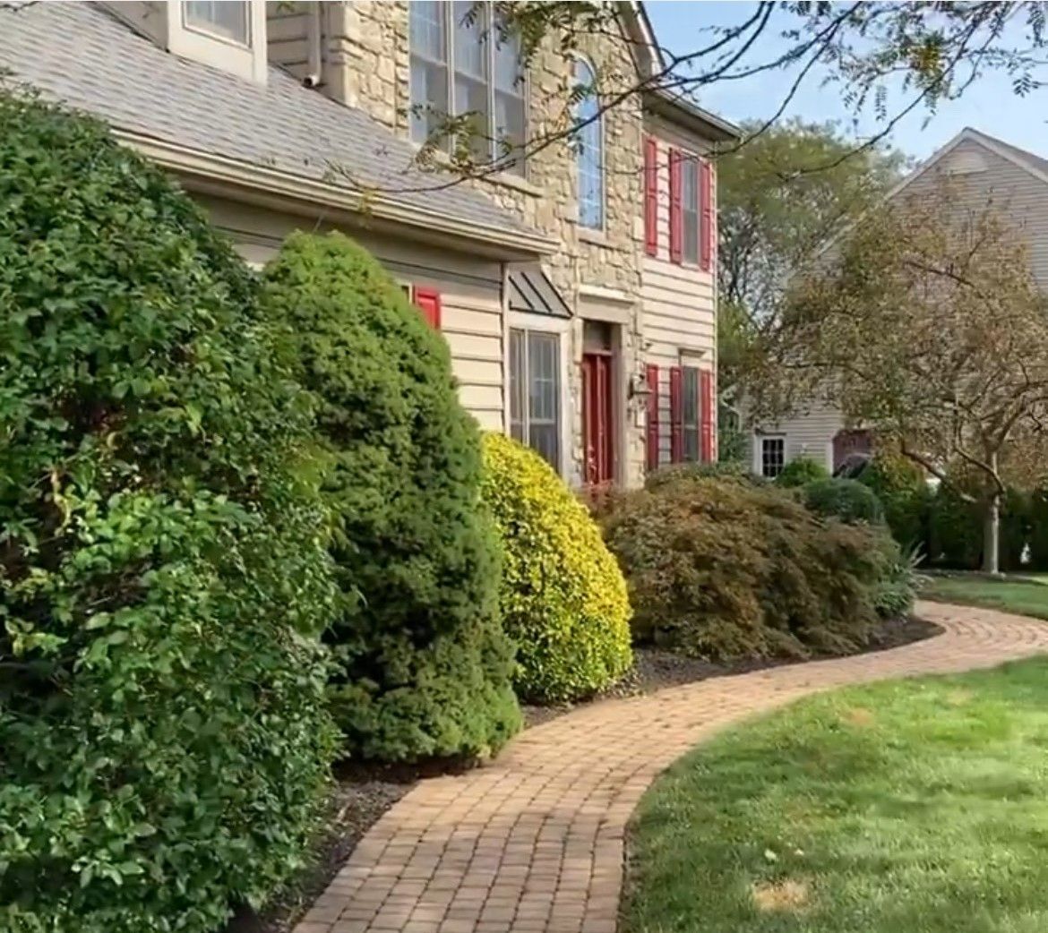 A house with a brick walkway leading to it.