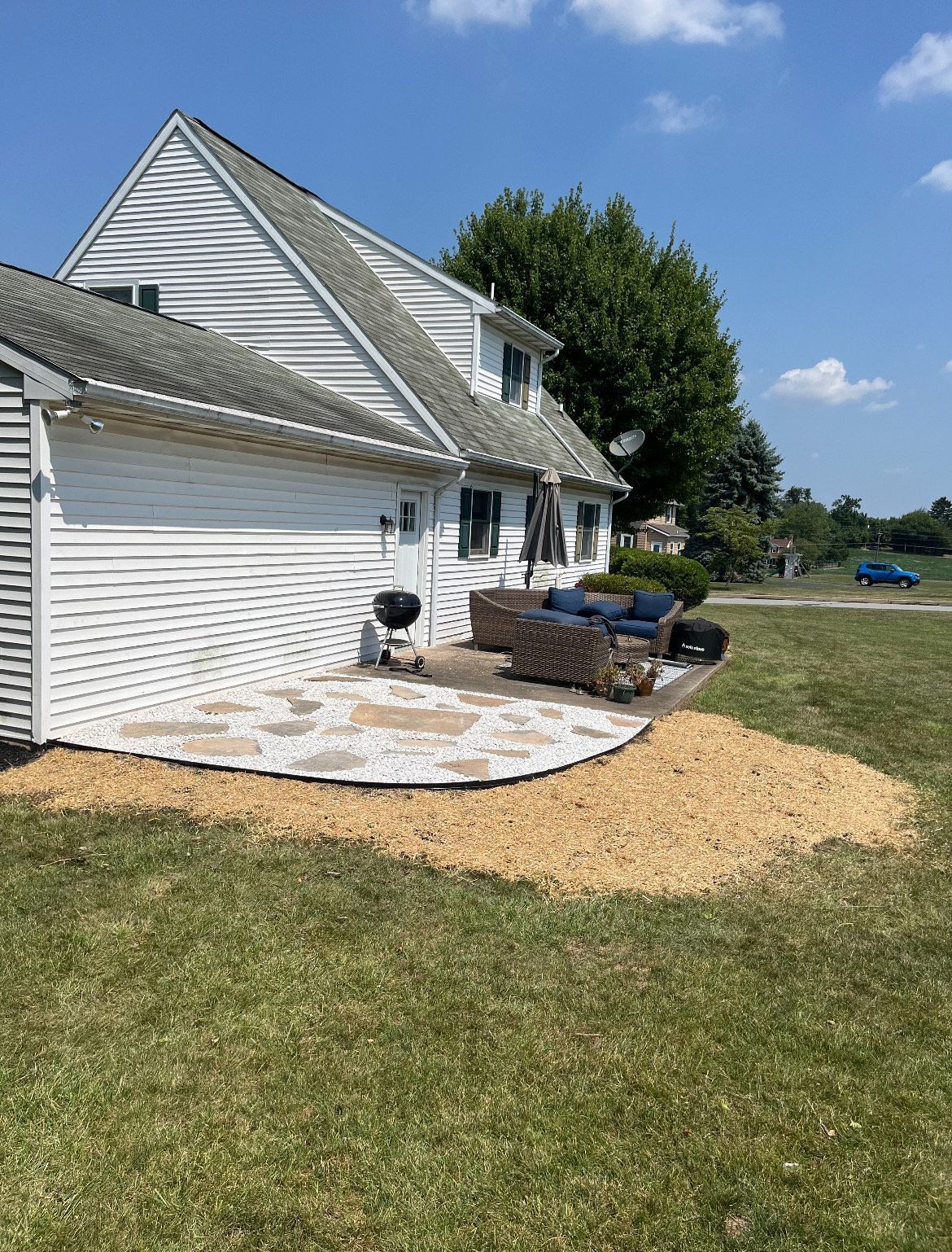A white house with a patio in front of it.