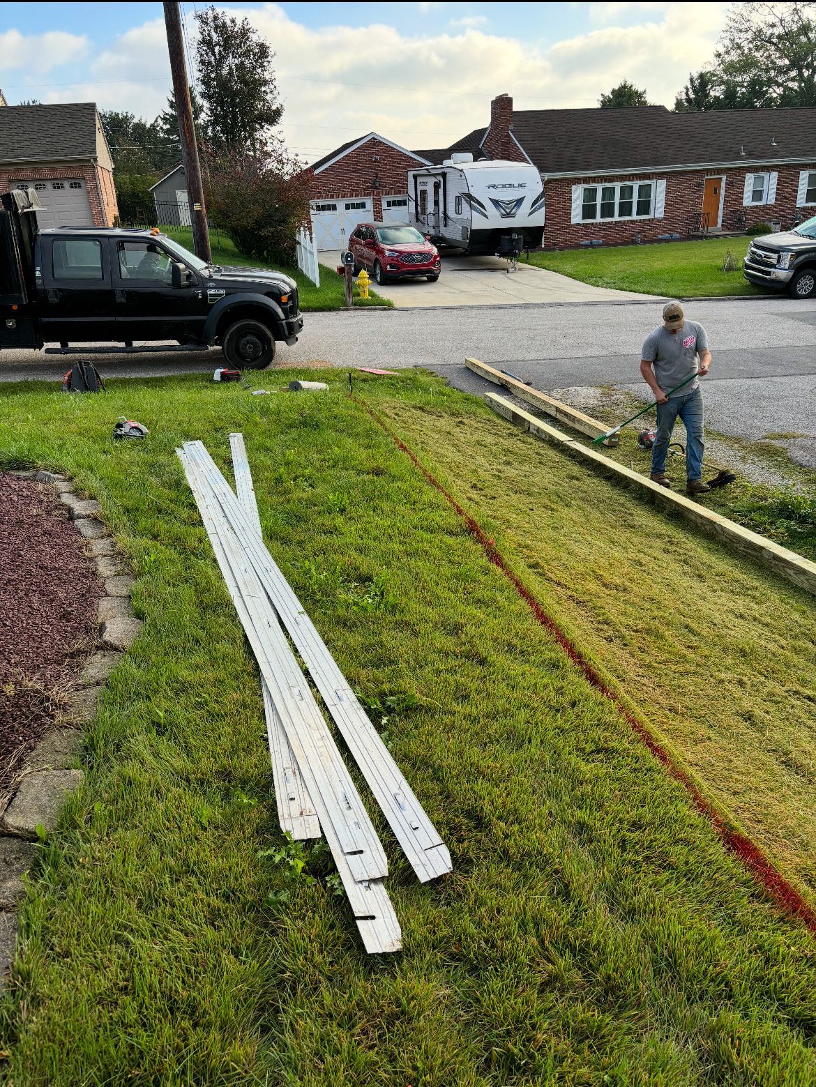 A man is standing in the grass next to a truck.