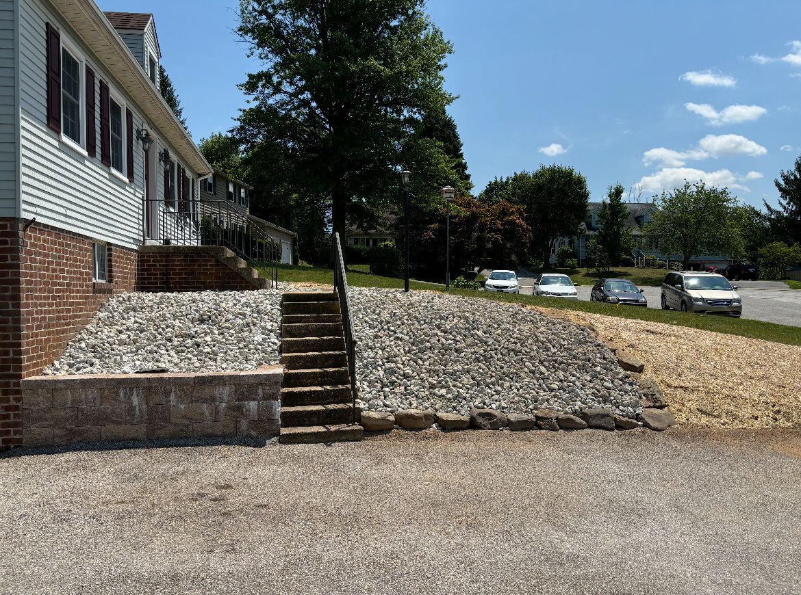 A driveway with stairs leading up to a house.