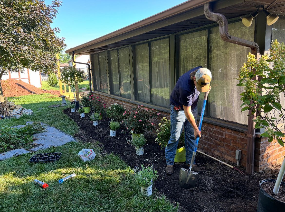 A man is digging in the dirt in front of a house.