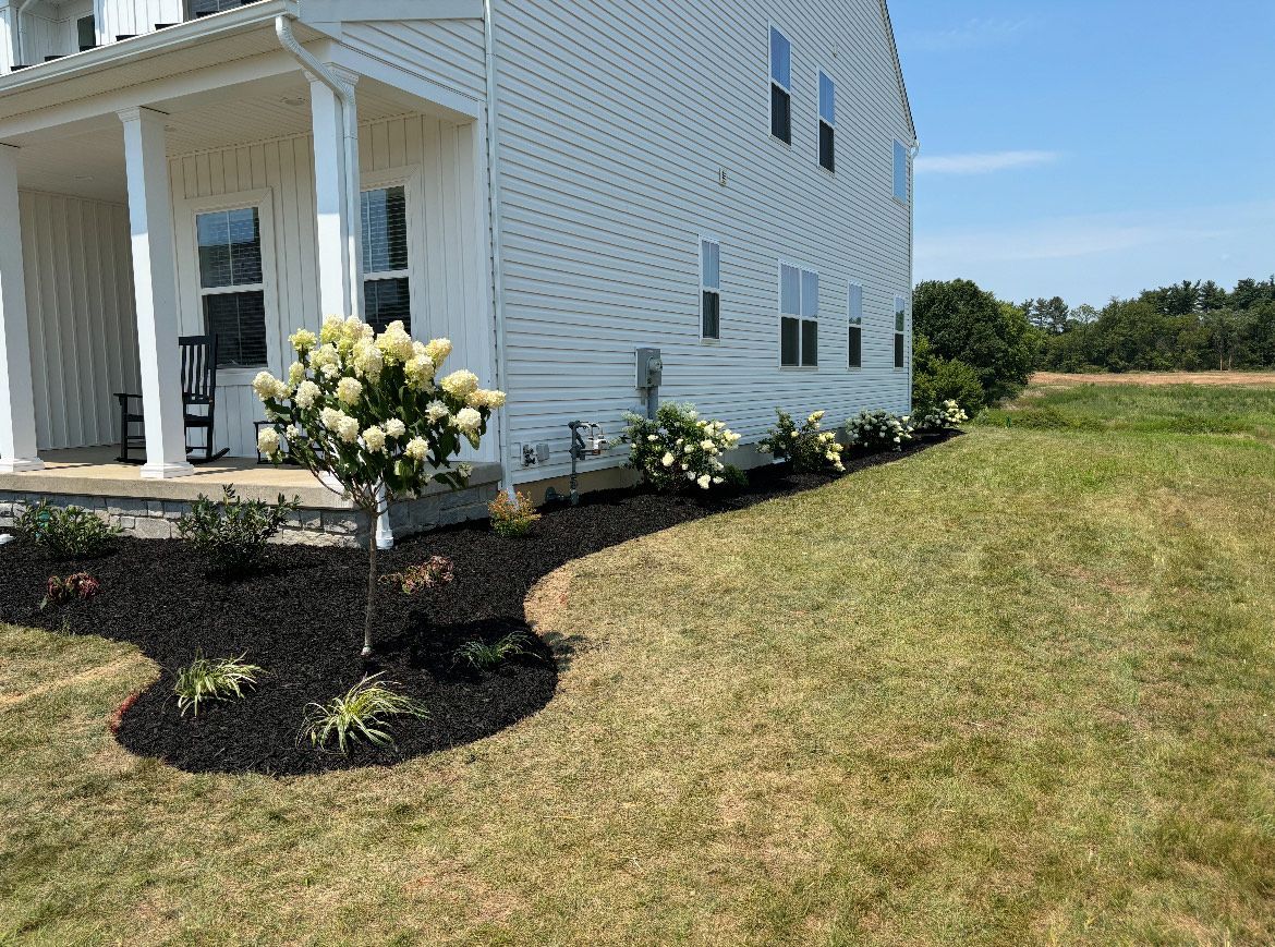 A white house with a large lawn in front of it.
