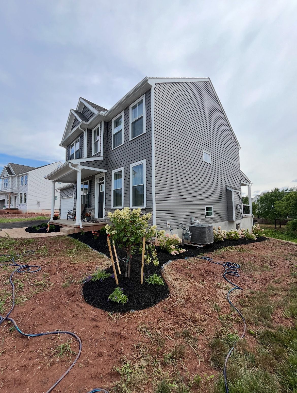 A large house with a lot of windows is sitting on top of a dirt field.