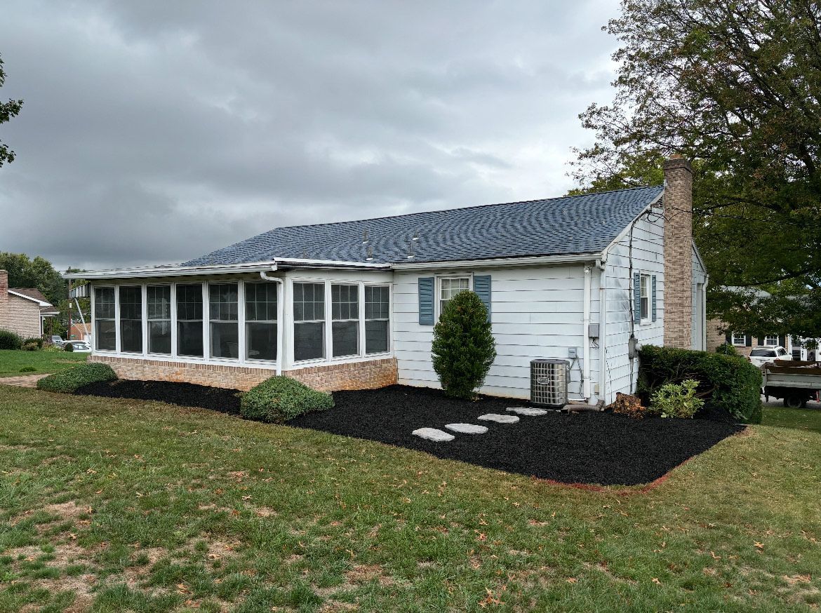 A white house with a screened in porch and a blue roof.