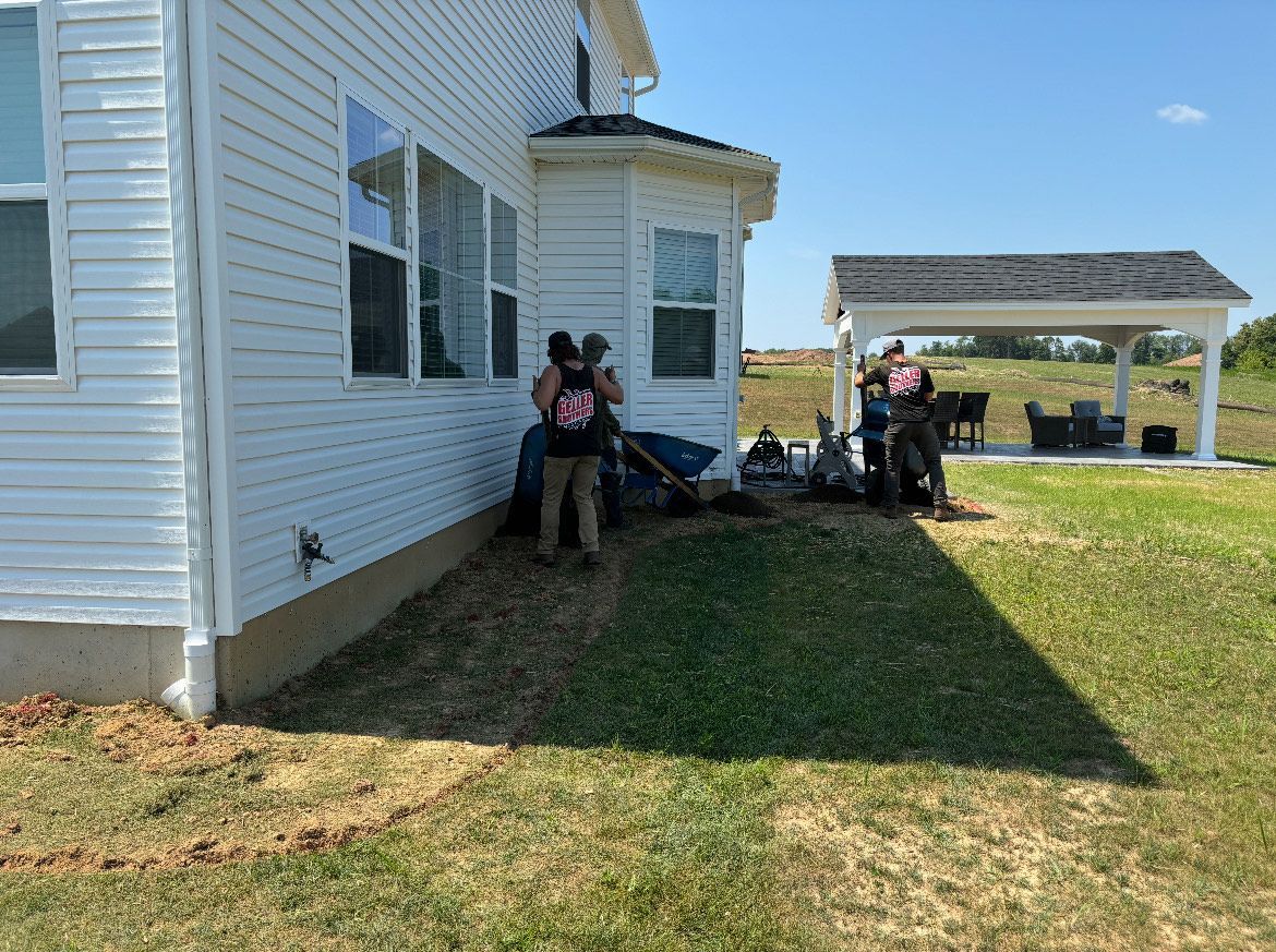 A group of people are standing in front of a white house.