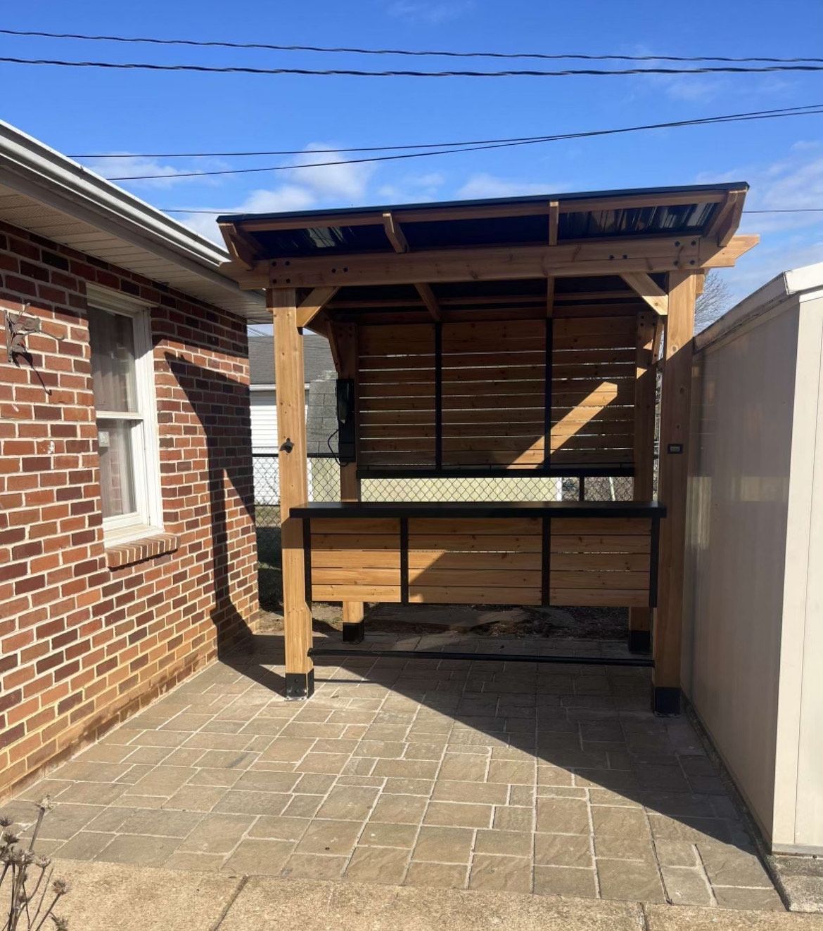 A brick building with a wooden structure in front of it.