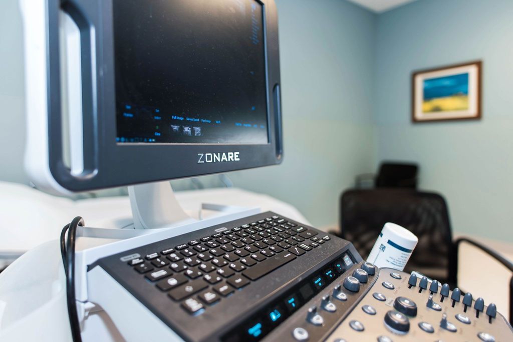 A computer monitor is sitting on top of a keyboard in a room.