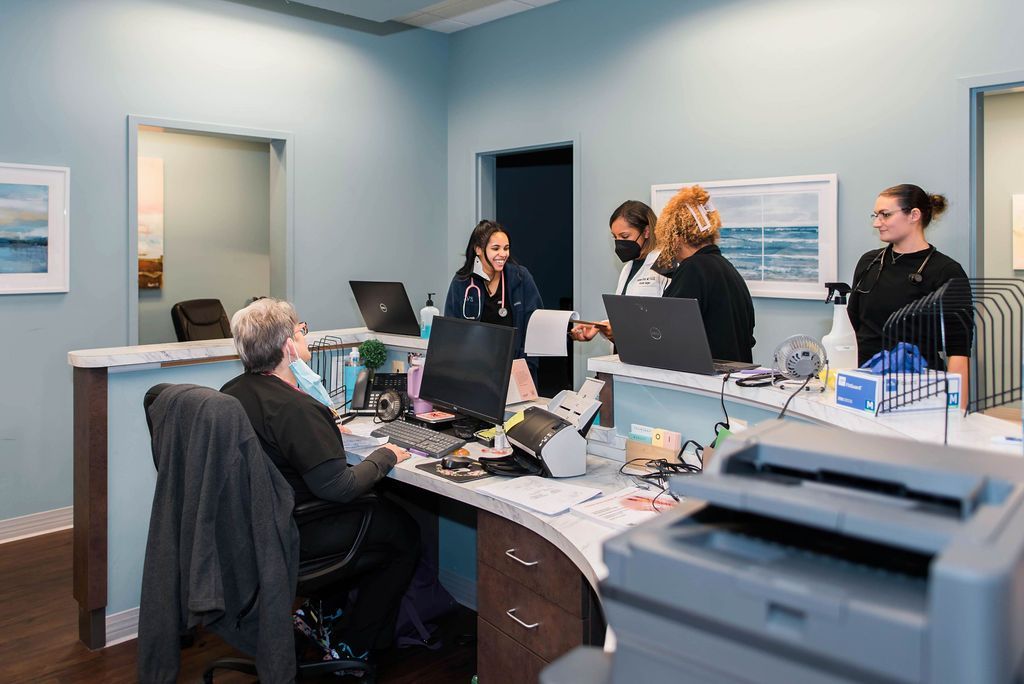 A doctor is sitting at a desk talking to another doctor