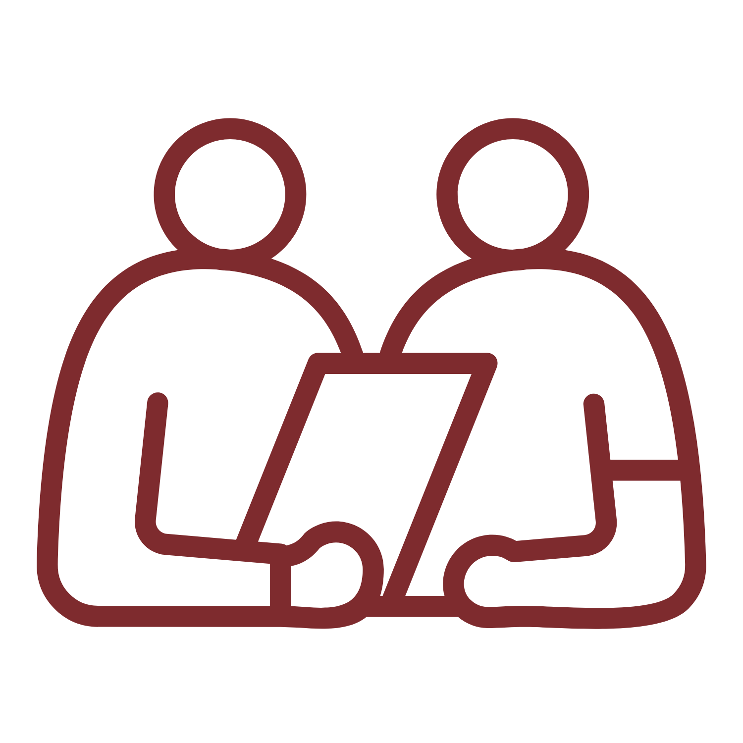Two people are sitting next to each other looking at a piece of paper.