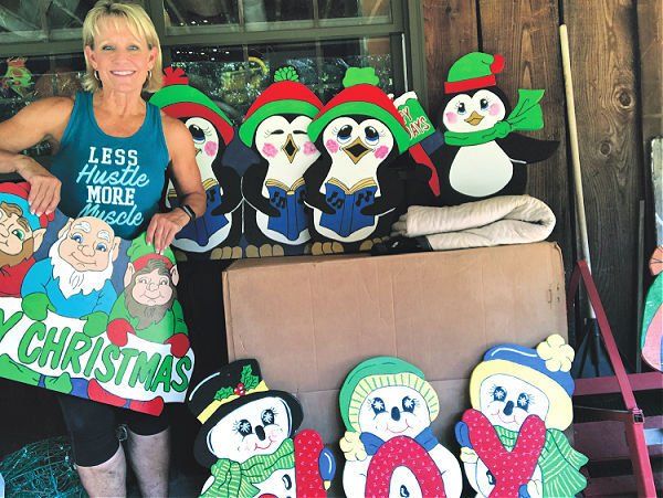 A woman is holding a sign that says christmas