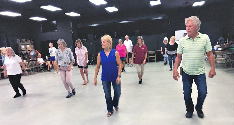 A group of people are dancing in a room.