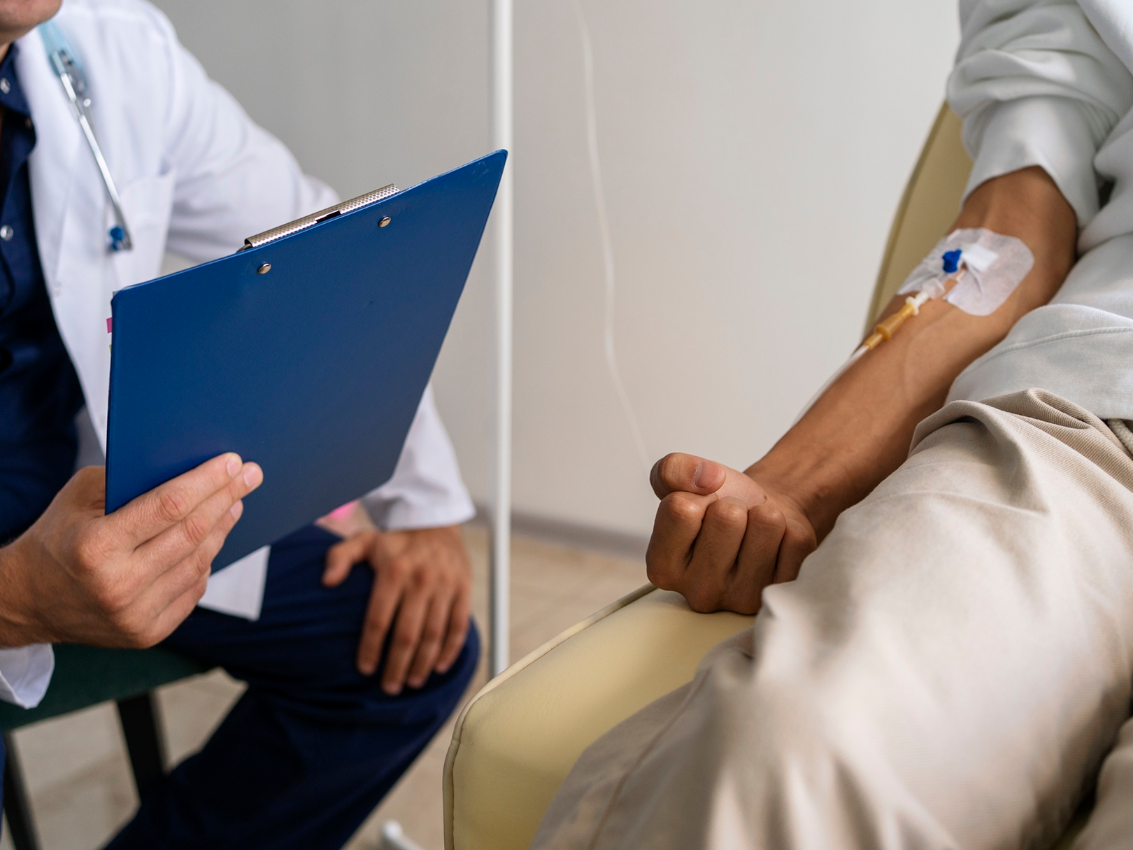 A doctor is talking to a patient with an iv in his arm.