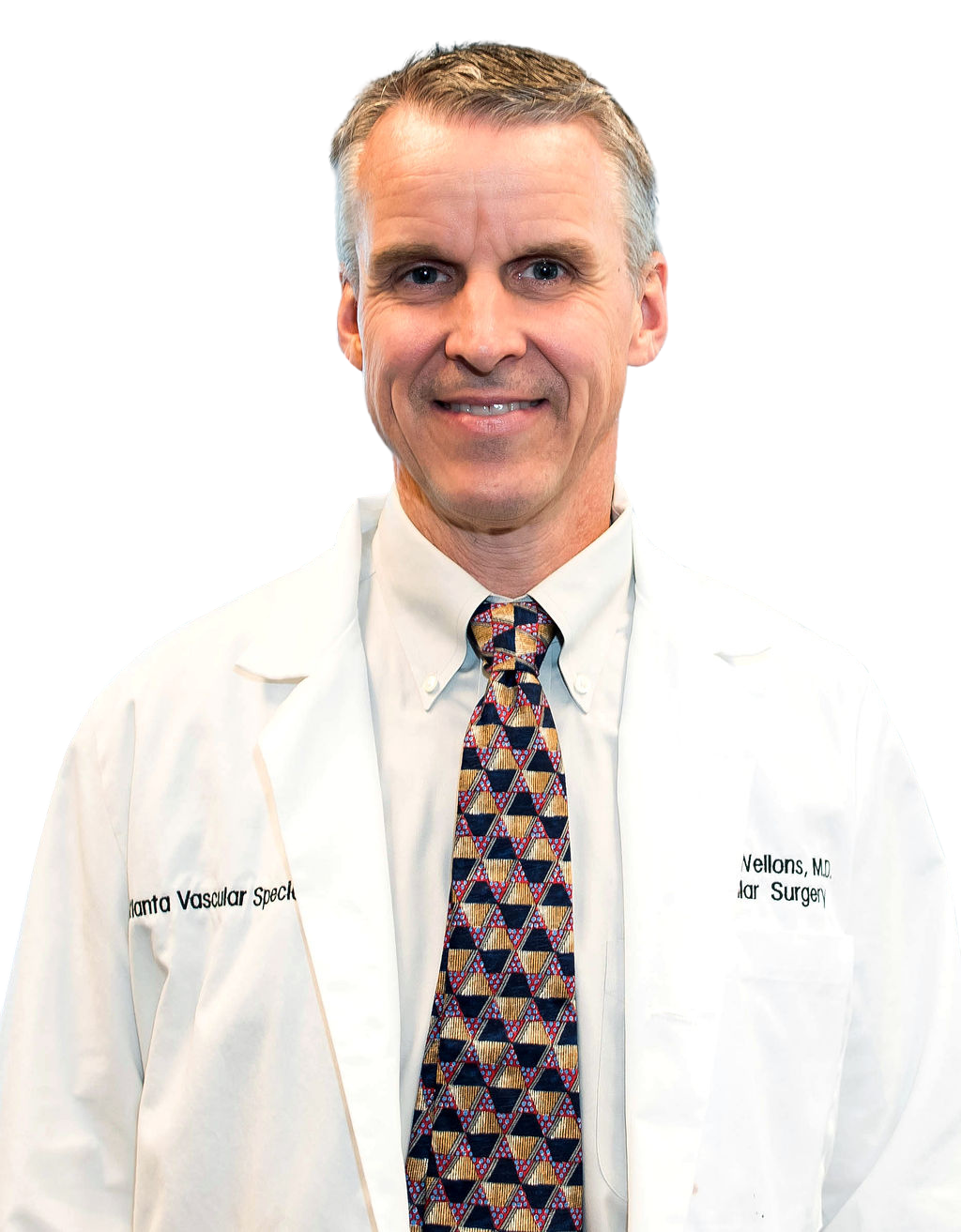 A man in a white coat and tie is smiling for the camera.