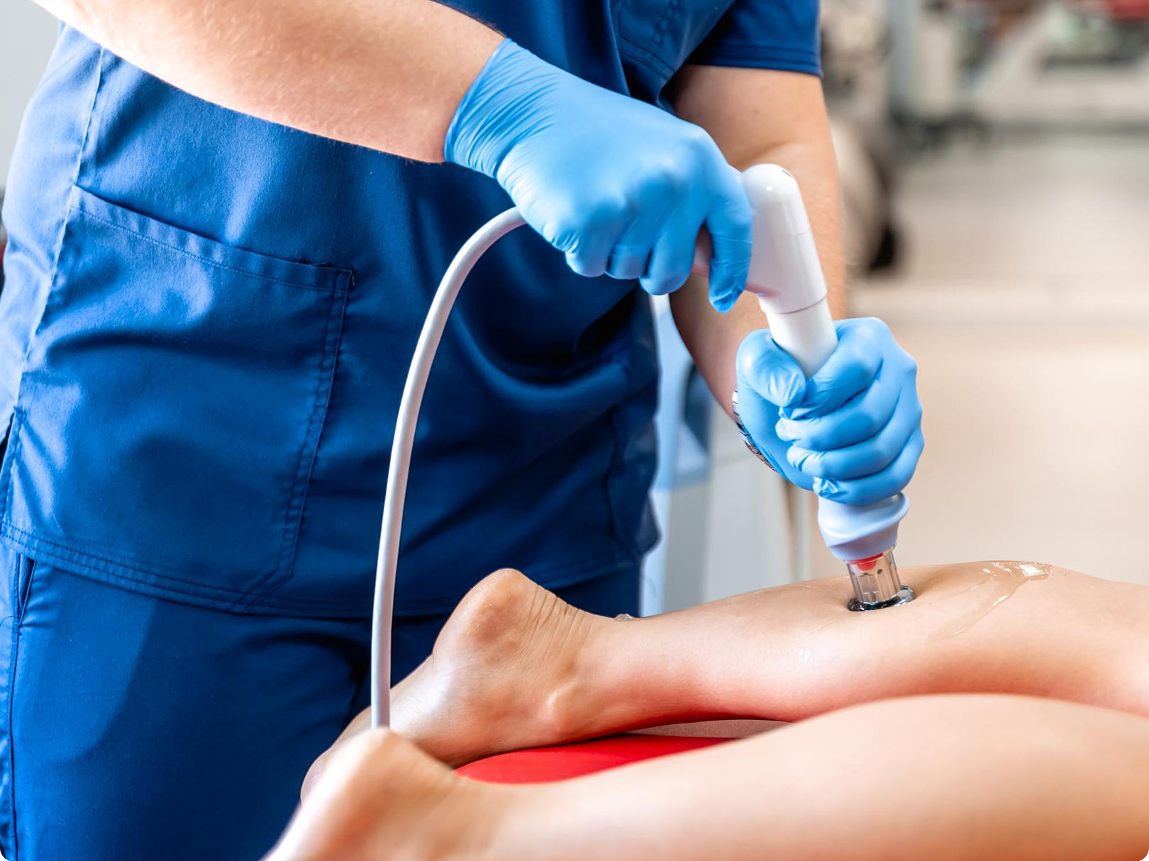 A nurse is using a machine on a patient 's leg.