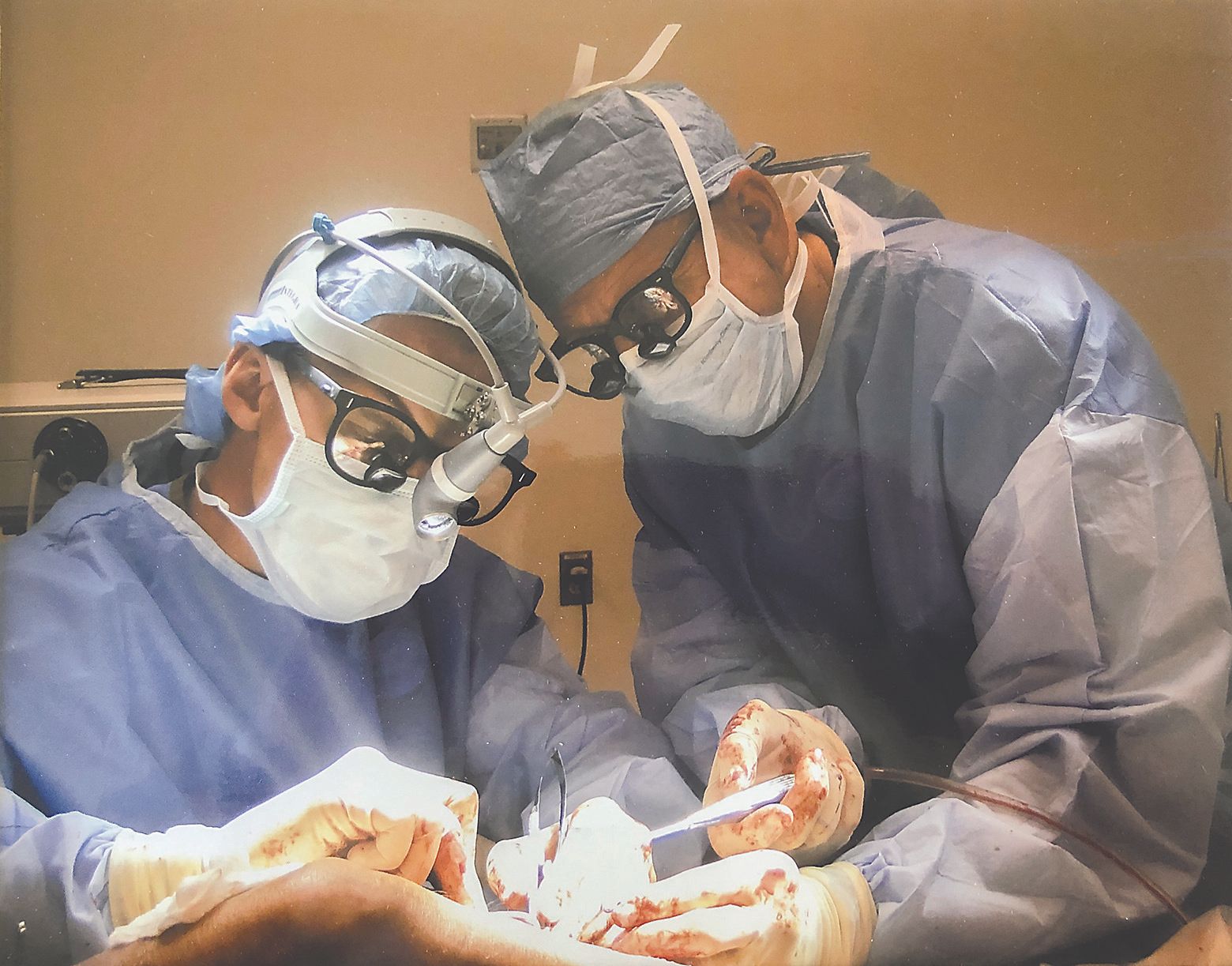Two surgeons are operating on a patient in an operating room