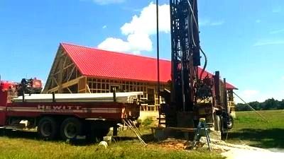 A red truck is parked in front of a house with a red roof.