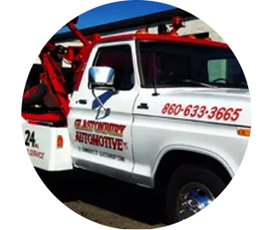 A white Glastonbury Automotive tow truck with red lettering and accents, viewed from the side.