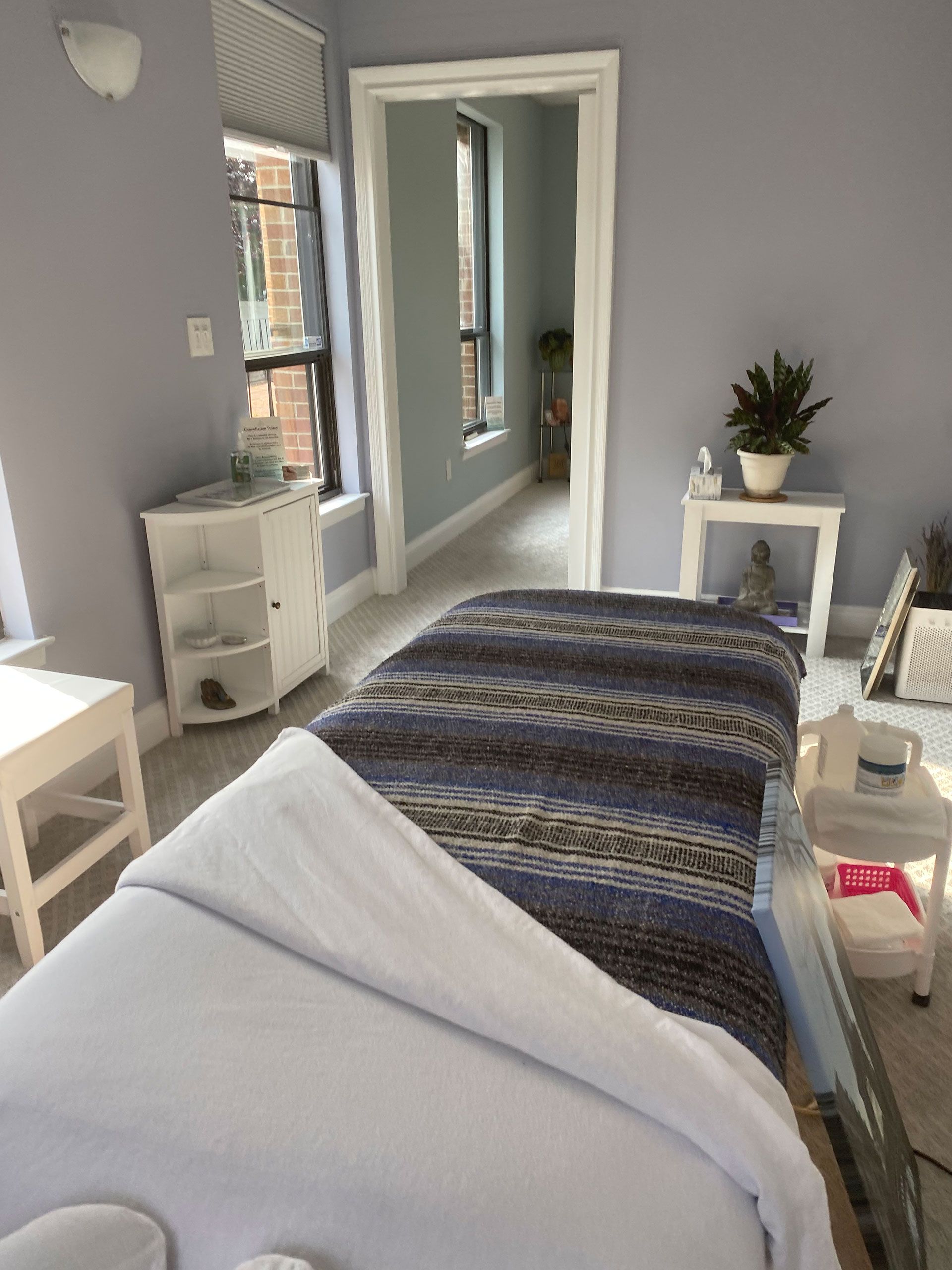 A bedroom with a bed and a plant on a table
