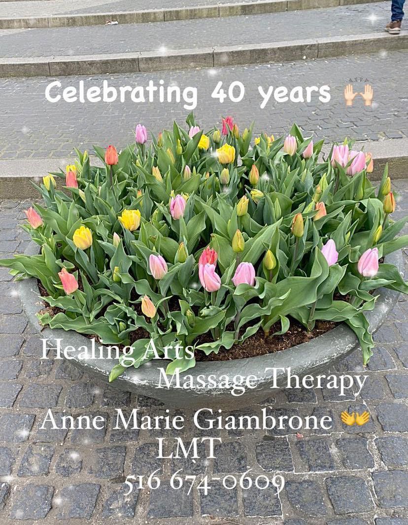 A bunch of flowers are growing in a pot on the side of the road