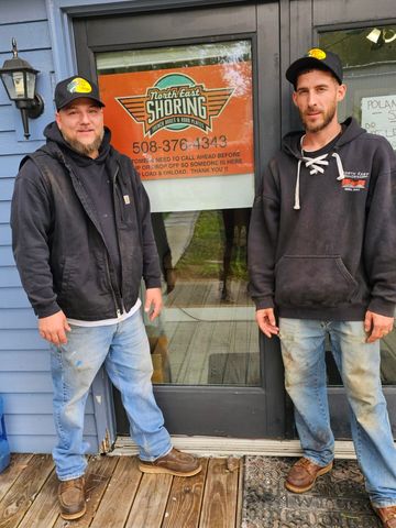 Two men are standing next to each other in front of a building.