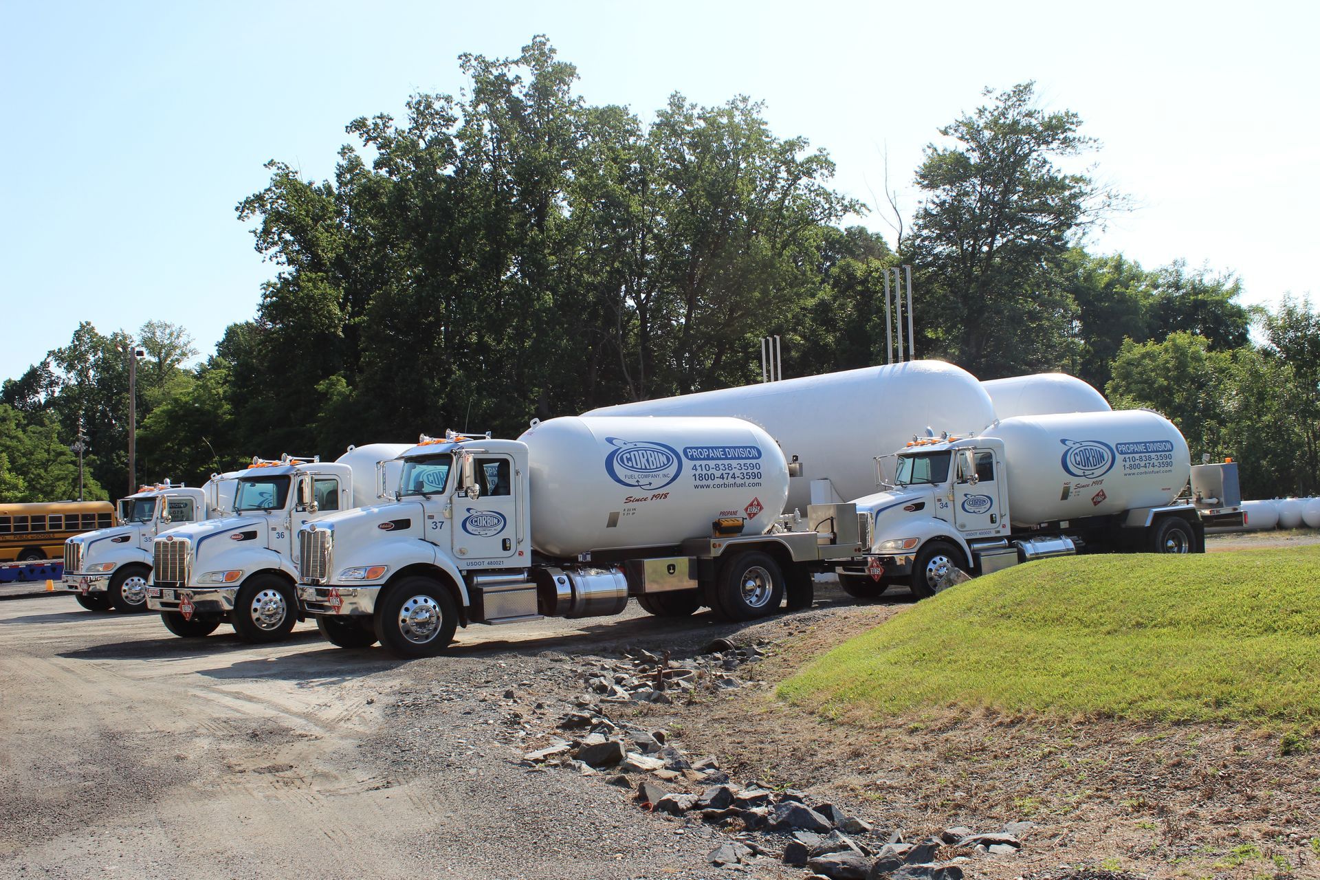 White cement mixer trucks parked beside a road in a sunny industrial area