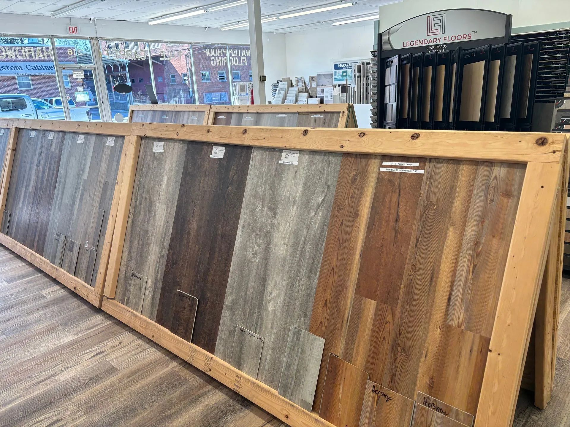 Displays of wood flooring samples in a showroom, various colors and textures.