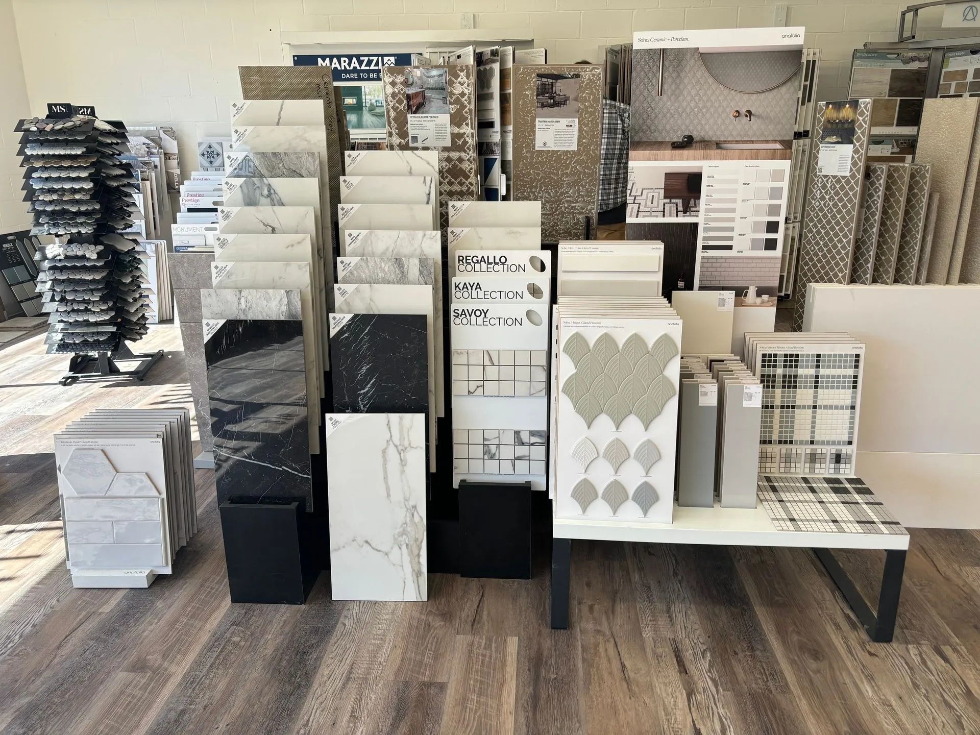 Tile samples on display in a showroom, showcasing various colors, patterns, and textures.